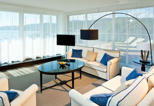 Living area of a hotel room with sofas and glass front